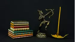 Statue bénie d’Indra en laiton présentée avec des livres