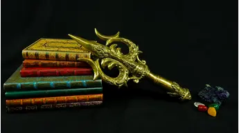 Trishula doré posé sur des livres