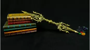 Trishula Vajra doré en laiton présenté sur des livres