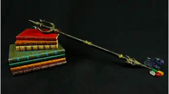 Trishula en laiton présenté sur des livres