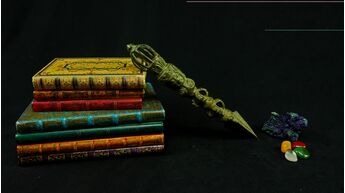 Grand phurba vert présenté sur des livres