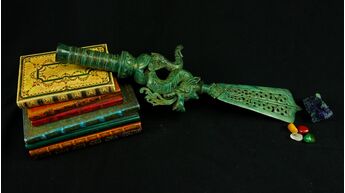 Grande dague rituelle Dragon n°1 présentée sur des livres