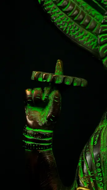 Détail de la main de Dhanvantari tenant un objet rituel