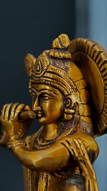 Détail de la statue bénie de Krishna jouant de la flûte