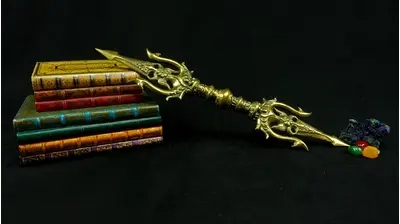 Trishula Vajra doré en laiton présenté sur des livres