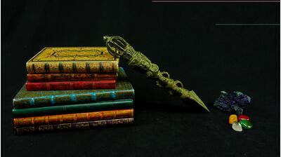 Grand phurba vert présenté sur des livres