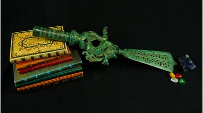 Grande dague rituelle Dragon n°1 présentée sur des livres